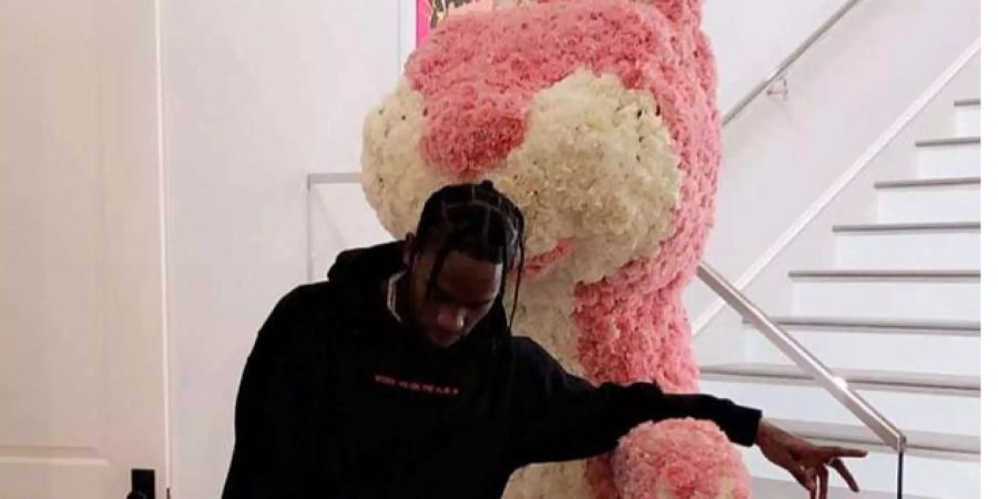 Kylie Jenners Freund Travis Scott posiert vor einem riesen Osterhasen.