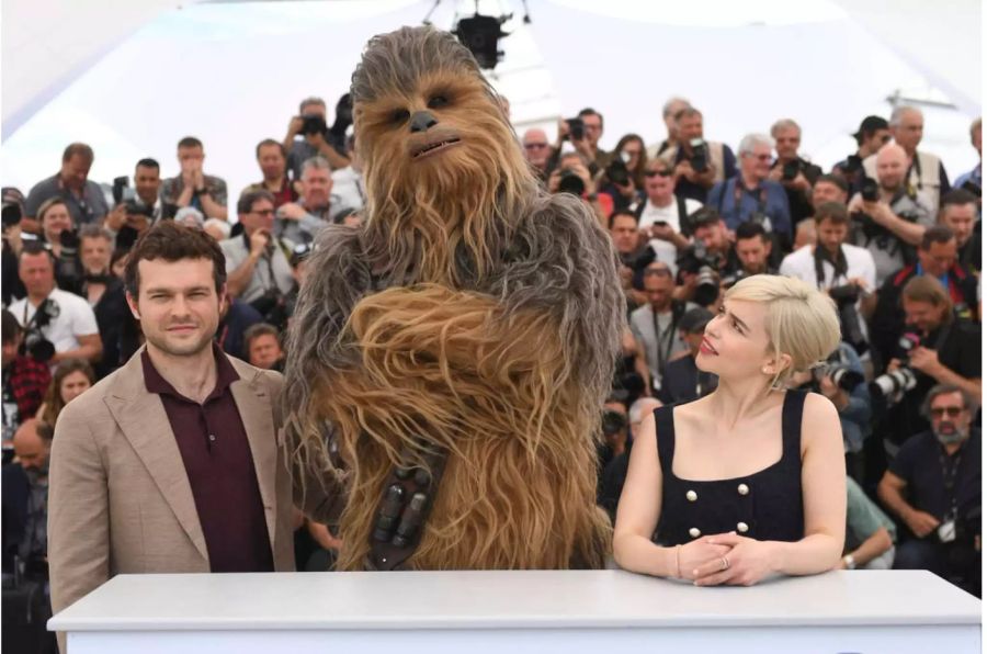 Aiden Ehrenreich und Emilia Clarke posieren mit Chewbacca für die Fotografen.