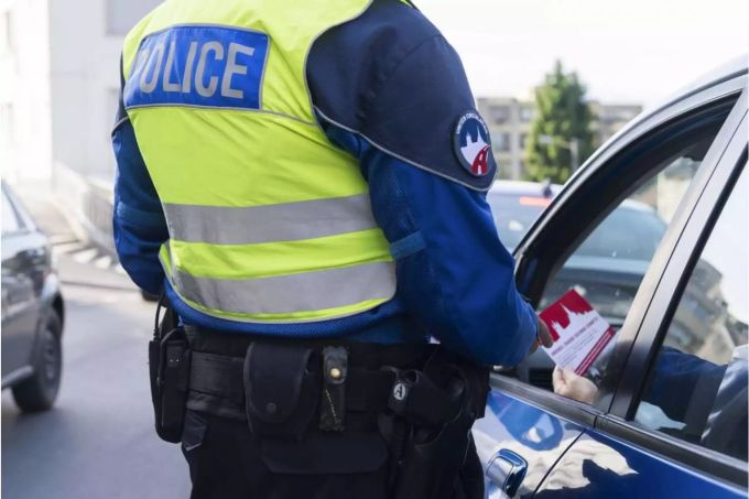 Polizist spricht mit Autolenker - Keystone Polizist spricht mit Autolenker - Keystone