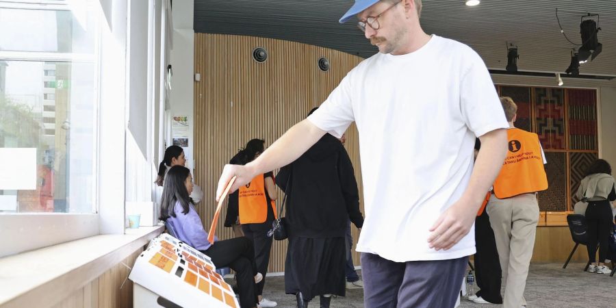 Ein Mann gibt in einem Wahllokal in Auckland seine Stimme für die Parlamentswahlen ab. Es zeichnet sich eine hohe Wahlbeteiligung ab.