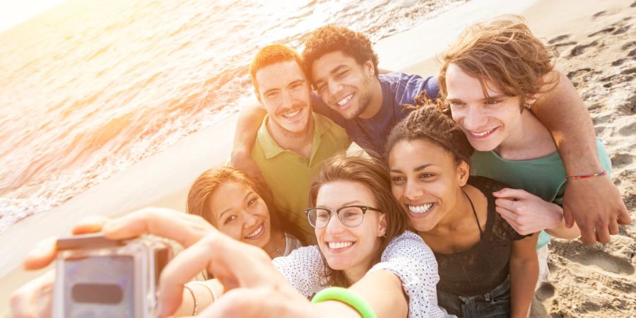 gruppe von jungen menschen macht selfie am strand