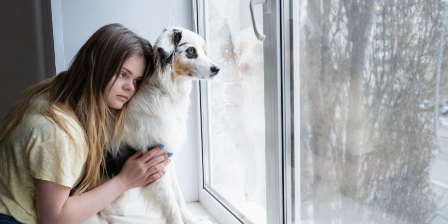 Frau mit Hund am Fenster