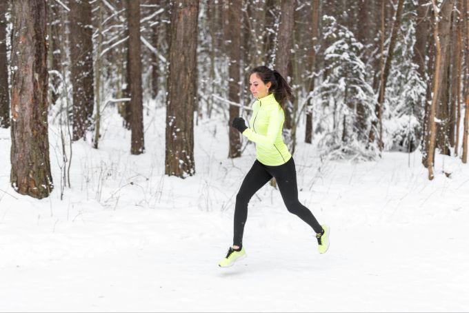 Bei einer leichten Erkältung ist Sport noch möglich. fRau joggt im Schnee