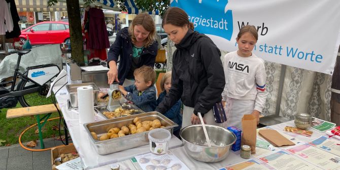 Erwachsene und Kinder am Infostand