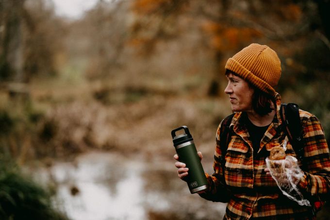 Eine Thermosflasche freut Outdoor-Fans. Frau hält Thermosflasche