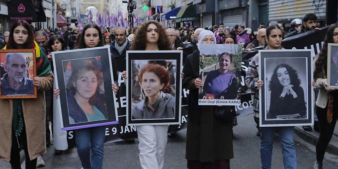 FILED - Menschen halten Poster mit den Gesichtern der bei dem Angriff getöteten Kurden in Paris. schiesserei paris