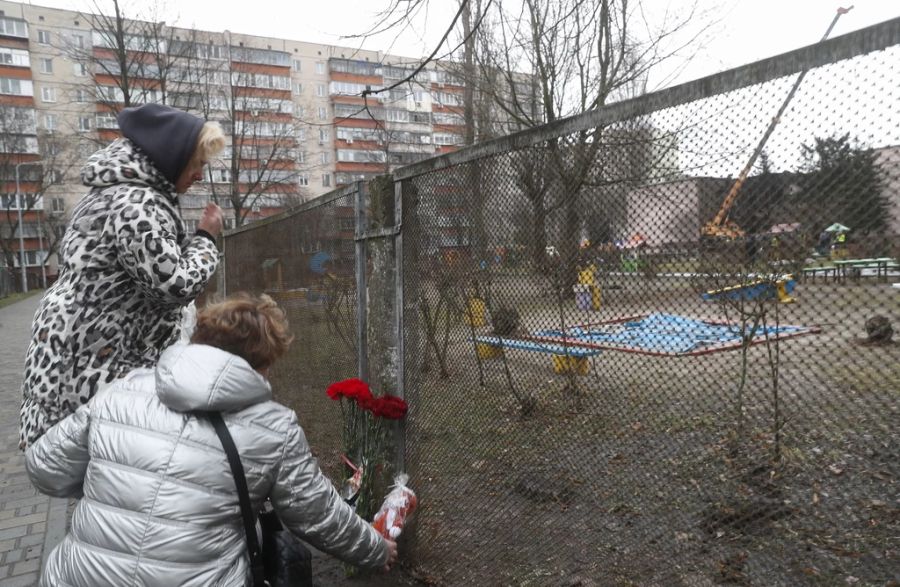 Anwohner legen Blumen für die Opfer des Unglücks an einen Zaun.