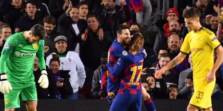 Zwischen Dortmunds geschlagenem Torhüter Roman Bürki (l) und Julian Weigl (r) feiert Lionel Messi (M) seinen Treffer zum 2:0 für den FC Barcelona mit Antoine Griezmann. Foto: Marius Becker/dpa