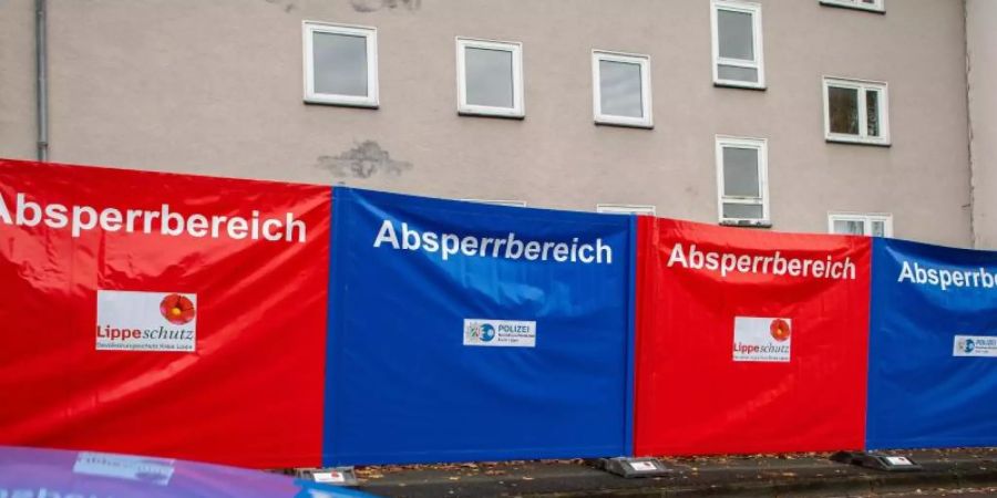 Sicht- und Zutrittssperren vor dem Haus, wo eine 15-Jährige ihren dreijährigen Halbbruder mit einem Messer getötet haben soll. Foto: Guido Kirchner/dpa