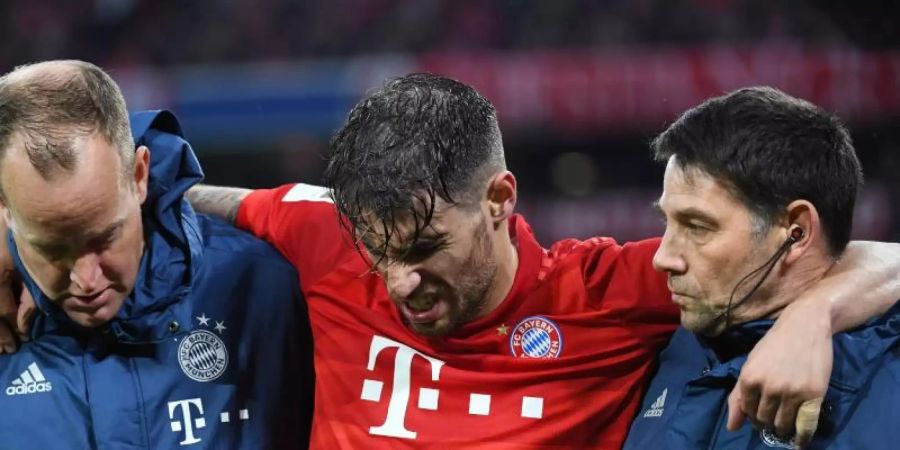Münchens Javi Martinez (M) wird verletzt vom Platz gebracht. Foto: Angelika Warmuth/dpa