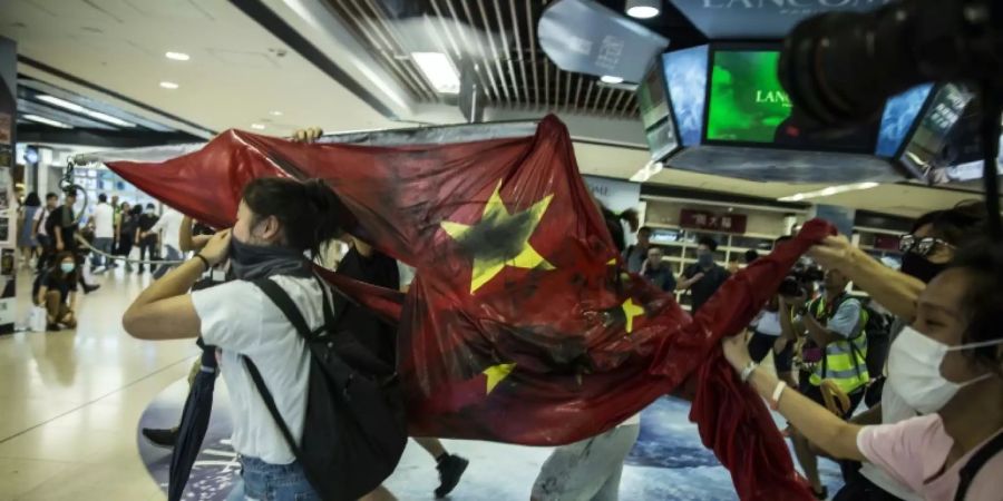 Demonstranten in Hongkong it einer herabgeholten chinesischen Flagge