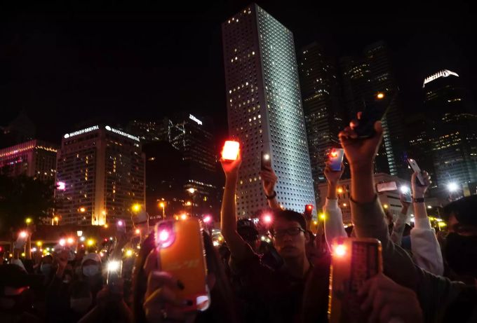 Menschen halten ihre Handys während einer Kundgebung in Hongkong nach oben. Proteste in Hongkong