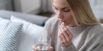 Frau nimmt Medikament ein