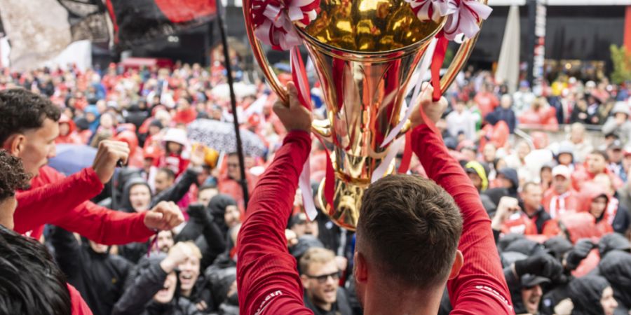 Torhüter Niklas Steffen stemmt den Pokal des Schweizer Fussballmeisters in die Höhe.