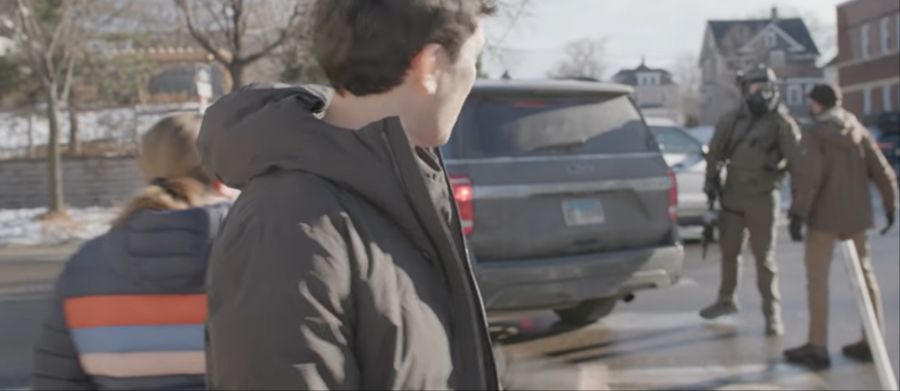 Im Hintergrund ist zu sehen, wie Alex Pretti einen ICE-Beamten konfrontiert.