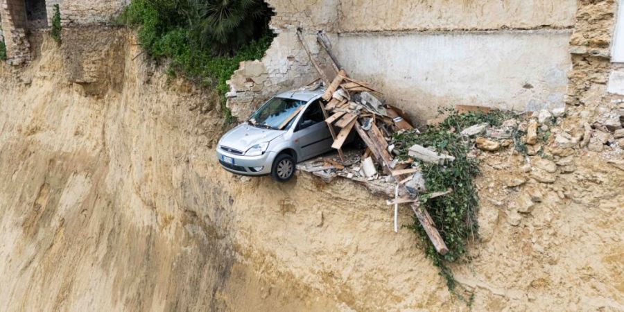 dpatopbilder - In dem Dorf Niscemi ist ein Auto vor einem durch einen Erdrutsch entstandenen Abgrund zu sehen. Nach schweren Unwettern auf Sizilien hat sich in einer Stadt ein massiver ...