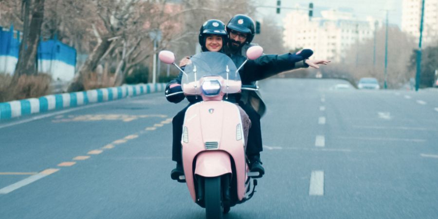 Auf einer rosafarbenen Vespa sausen Filmemacher Bahram und Produzentin Sadaf im Film «Divine Comedy» durch Teheran und suchen nach einem Spielort für ihren neusten Film.