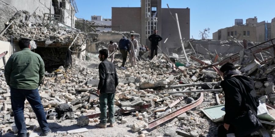 Eine Gruppe von Männern inspiziert die Ruinen einer Polizeistation, die am Montag im Rahmen der amerikanisch-israelischen Militäraktion getroffen wurde. Foto: Vahid Salemi/AP/dpa
