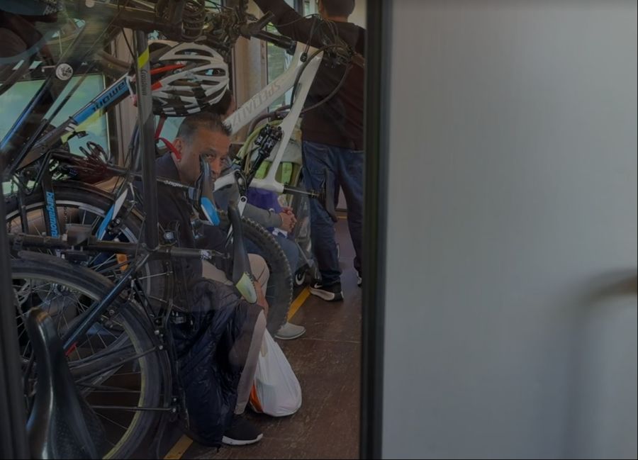 Eingepfercht sitzt ein Passagier im Velowagen der Zentralbahn.