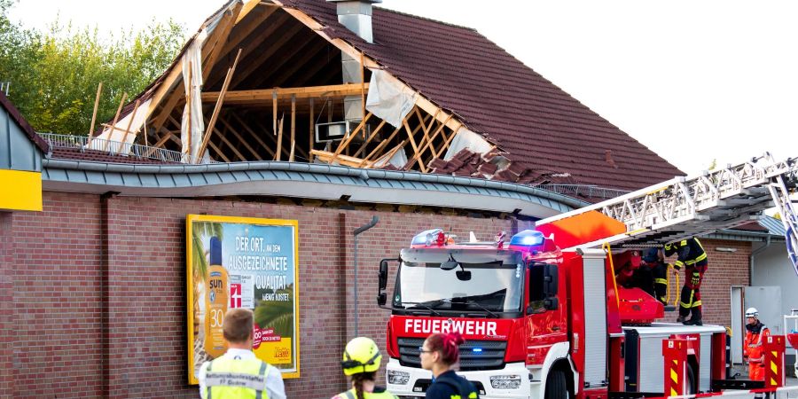 Einsatzkräfte stehen vor dem eingestürzten Supermarktdach in Ratzeburg.