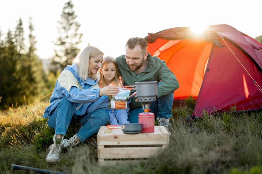 Familie vor Campingkocher.