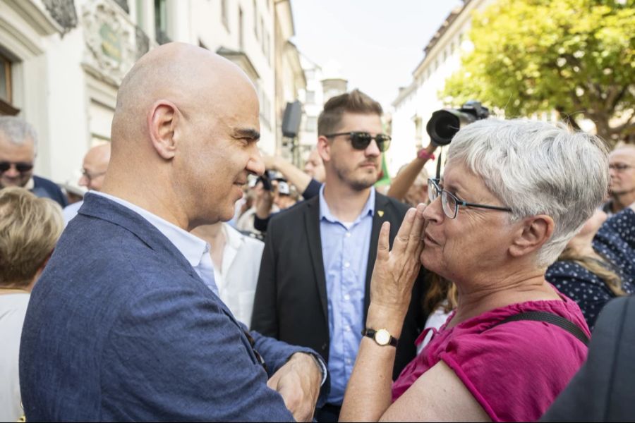 Alain Berset plaudert auf der Bundesratsreise 2022 mit einer Schaffhauserin, während ein Personenschützer die Umgebung im Blick hat.