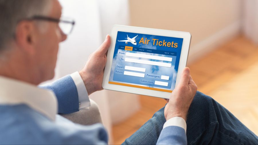 Mann am Tablet bei der Ticketbuchung