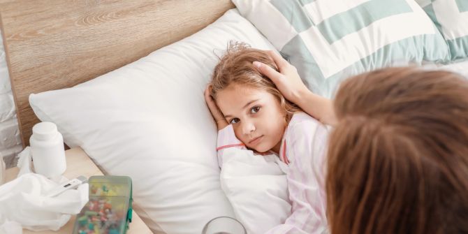 Krankes Kind im Bett, Mutter streichelt Kopf des Kindes