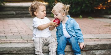 Kleinkinder teilen sich Apfel.