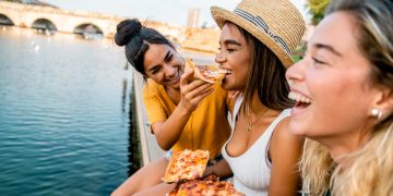 Frauen essen glücklich Pizza in Florenz