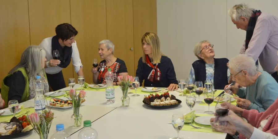 Senioren und Gmeinderatsmitglieder klönen am gedeckten Tisch