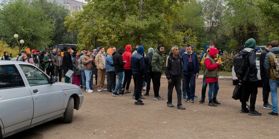 Russen stehen in einer Schlange, nachdem sie die Grenze nach Kasachstan überquert haben.