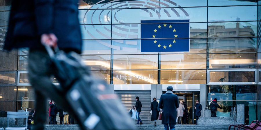 Passanten gehen vor dem Sitz des Europäischen Parlaments entlang.