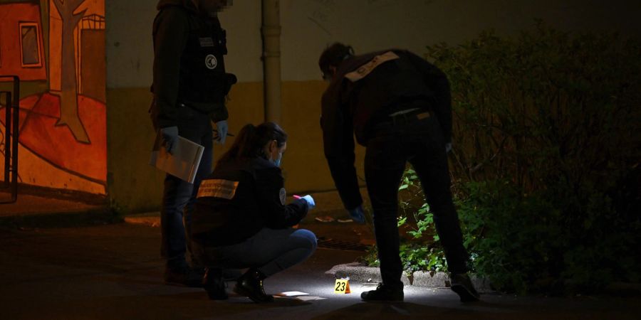 Forensiker der Polizei arbeiten am Tatort, an dem am Samstagabend Schüsse gefallen sind.