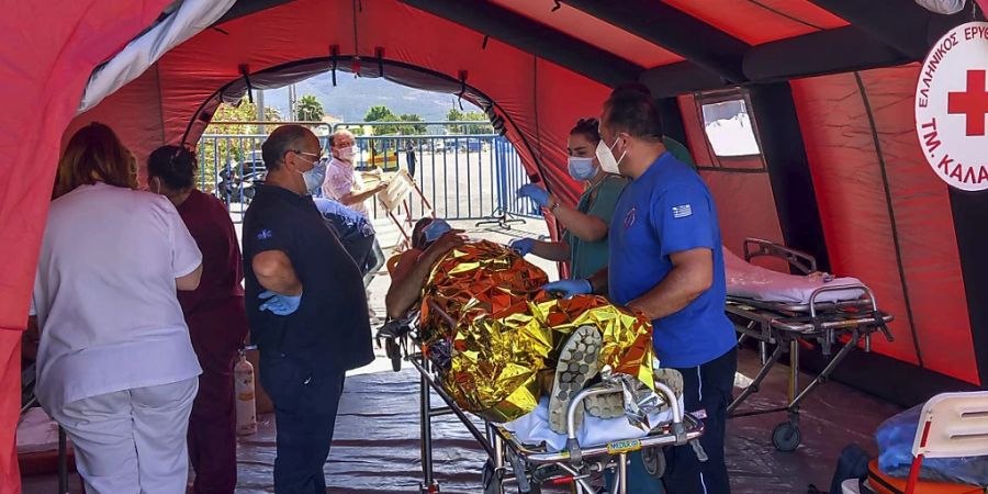 Ein Überlebender des Unfalls wird im griechischen Kalamata von Rettungskräften versorgt. Foto: Uncredited/www.argolikeseidhseis.gr/dpa