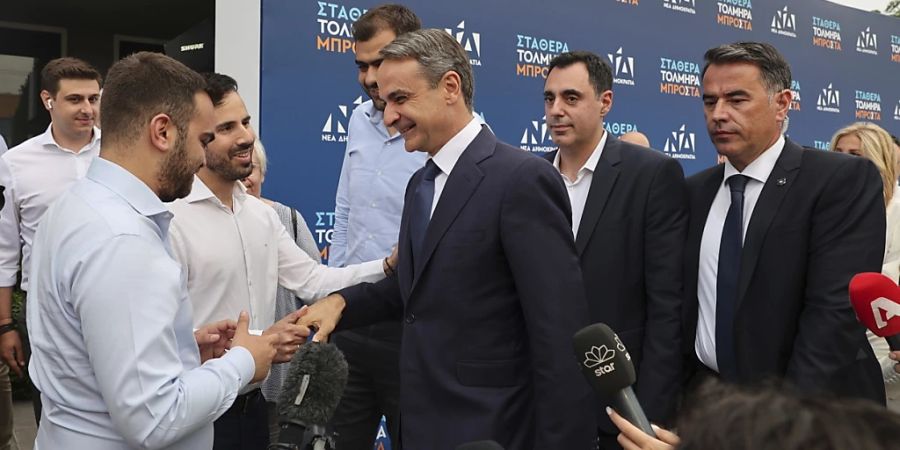 Kyriakos Mitsotakis (M), Vorsitzender der Mitte-Rechts-Partei Neue Demokratie, trifft an der Parteizentrale ein. Die konservative Partei ist bei der Parlamentswahl in Griechenland am Sonntag Prognosen zufolge stärkste Partei geworden. Foto: Yorgos Karahalis/AP/dpa