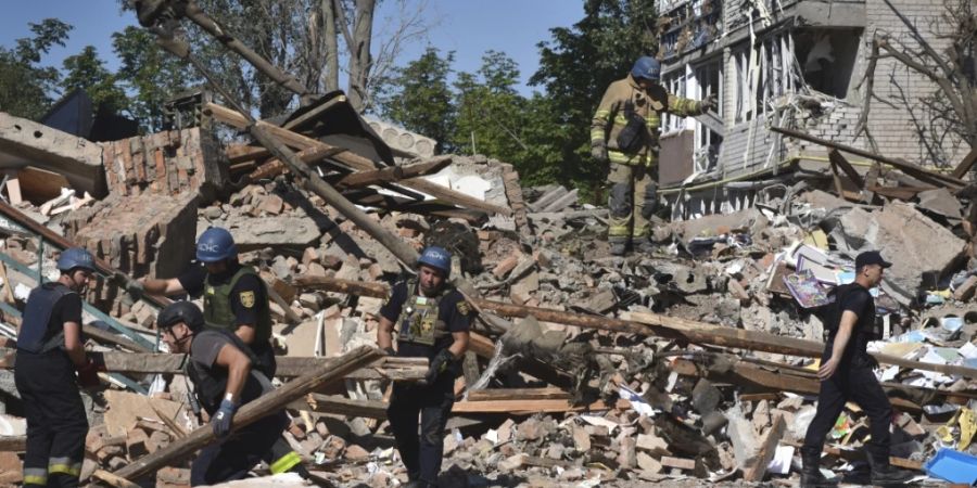 Ukrainische Rettungskräfte arbeiten nach einem russischen Angriff auf Orichiw in den Trümmern eines zerstörten Gebäudes. Foto: Andriy Andriyenko/AP/dpa