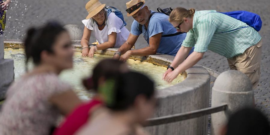 Touristen erfrischen sich in Rom: Eine intensive Hitzewelle hat Italien erreicht. Foto: Andrew Medichini/AP