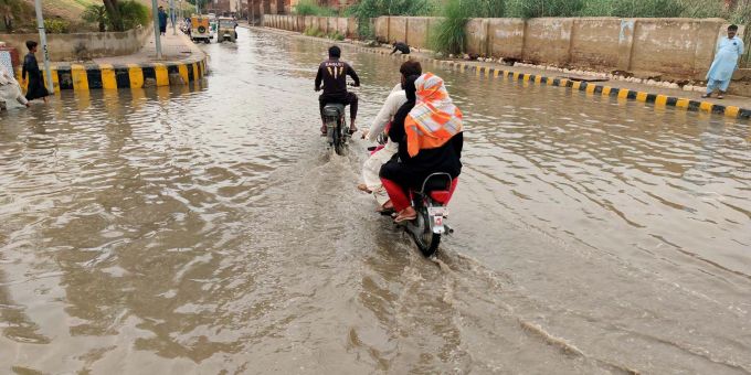 Überall Wasser: Menschen fahren durch überschwemmte Strassen nach starkem Monsunregen. Monsunregen Pakistan