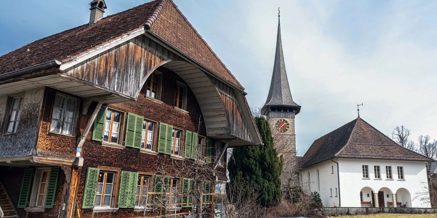 Die evangelische Kirche von Rüderswil und Bauernhaus.