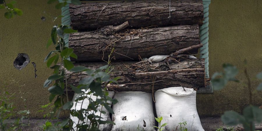 Mit Holzstämmen und Sandsäcken wird ein Fenster eines Wohnhauses vor russischem Beschuss geschützt. Russland beschiesst die Stadt täglich beim Versuch, die ukrainische Region Donbas zu erobern. Foto: Daniel Carde/ZUMA Press Wire/dpa