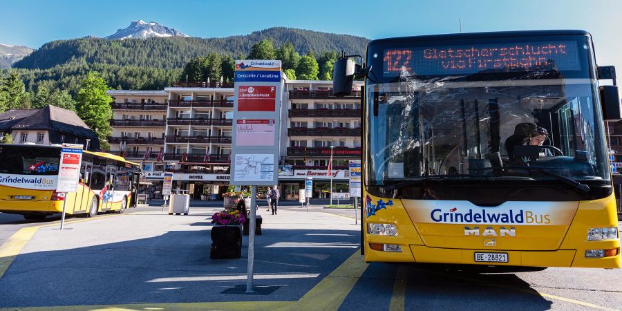 Die Busstation am Bahnhof Grindelwald mit einem Bus mit Fahrtrichtung Gletscherschlucht