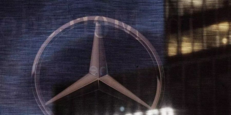 Die Daimler-Zentrale in Stuttgart ist durch eine Flagge zu sehen, auf der der Mercedes-Stern abegebildet ist. Foto: Marijan Murat/dpa