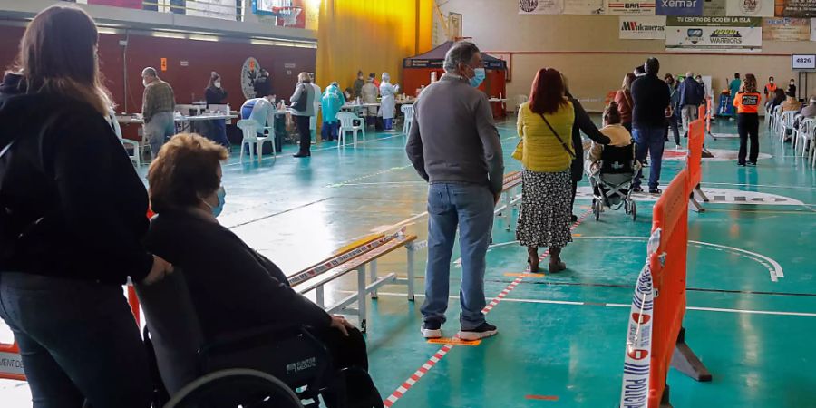 Menschen warten in einer Sporthalle in Lloseta, Mallorca, darauf, auf Covid-19 getestet zu werden. Foto: Clara Margais/dpa