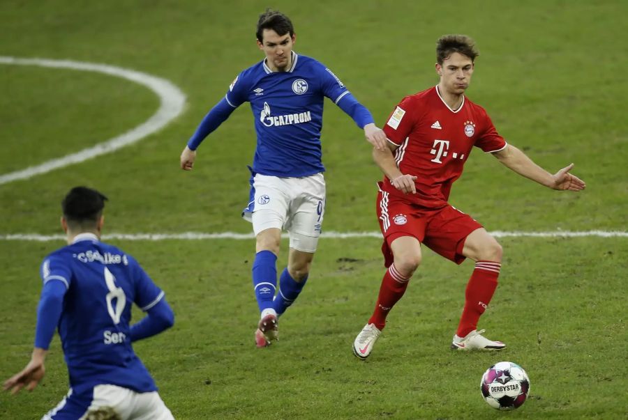 Bayerns Joshua Kimmich (r.) schirmt den Ball gegen Benito Raman (l.) von Schalke 04 ab.