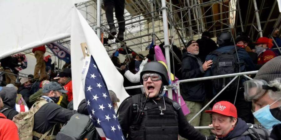 Polizist inmitten von Demonstranten am Kapitol