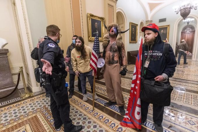 Der «Q Schamane» und seine verwirrten Freunde werdem von einem Polizisten aufgehalten. Donald Trump