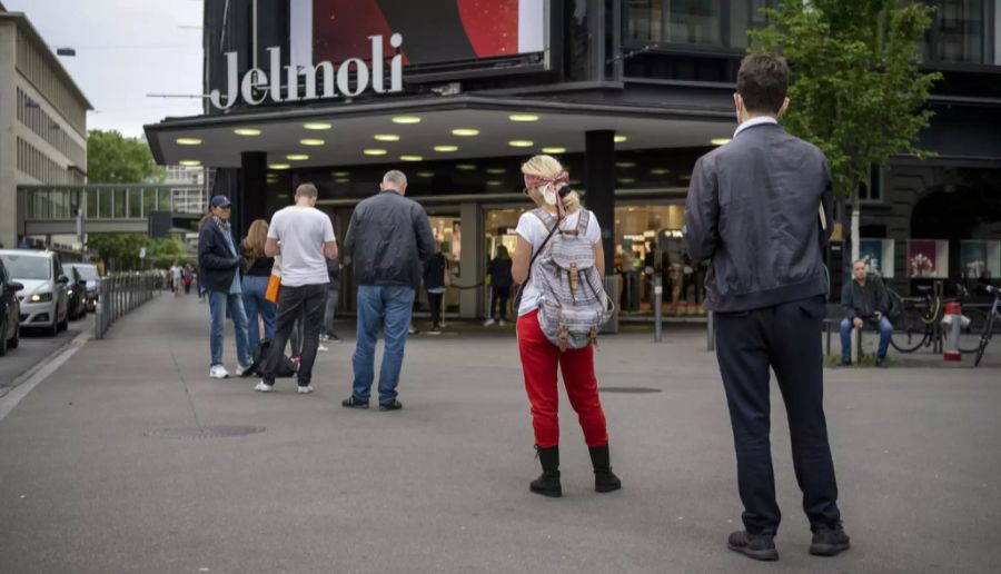 Personen warten vor dem Jelmoli.