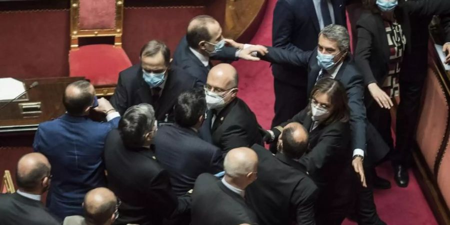 Platzanweiser (M) verhindern, dass Senatsmitglieder der Lega Nord (l) mit Mitgliedern der Demokratischen Partei im Senat aneinandergeraten. Foto: Roberto Monaldo/LaPresse/AP/dpa