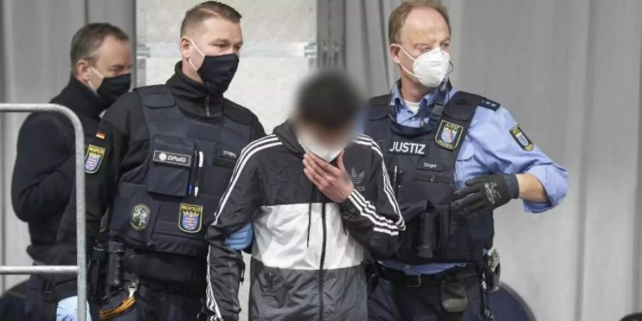 Der Angeklagte wird in den provisorisch in einem Festzelt eingerichteten Gerichtssaal geführt. Foto: Thomas Frey/dpa Pool/dpa